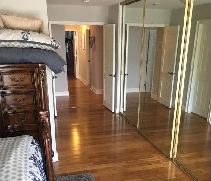 Master bedroom with laminate flooring and mirror closet doors
