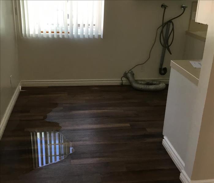 kitchen with puddled water on laminate flooring
