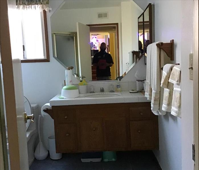 white tile bathroom with hexagonal mirror